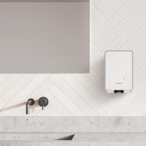 Dispenser elettronico per il sapone lavamani ICON di fianco ad un lavello e a uno specchio